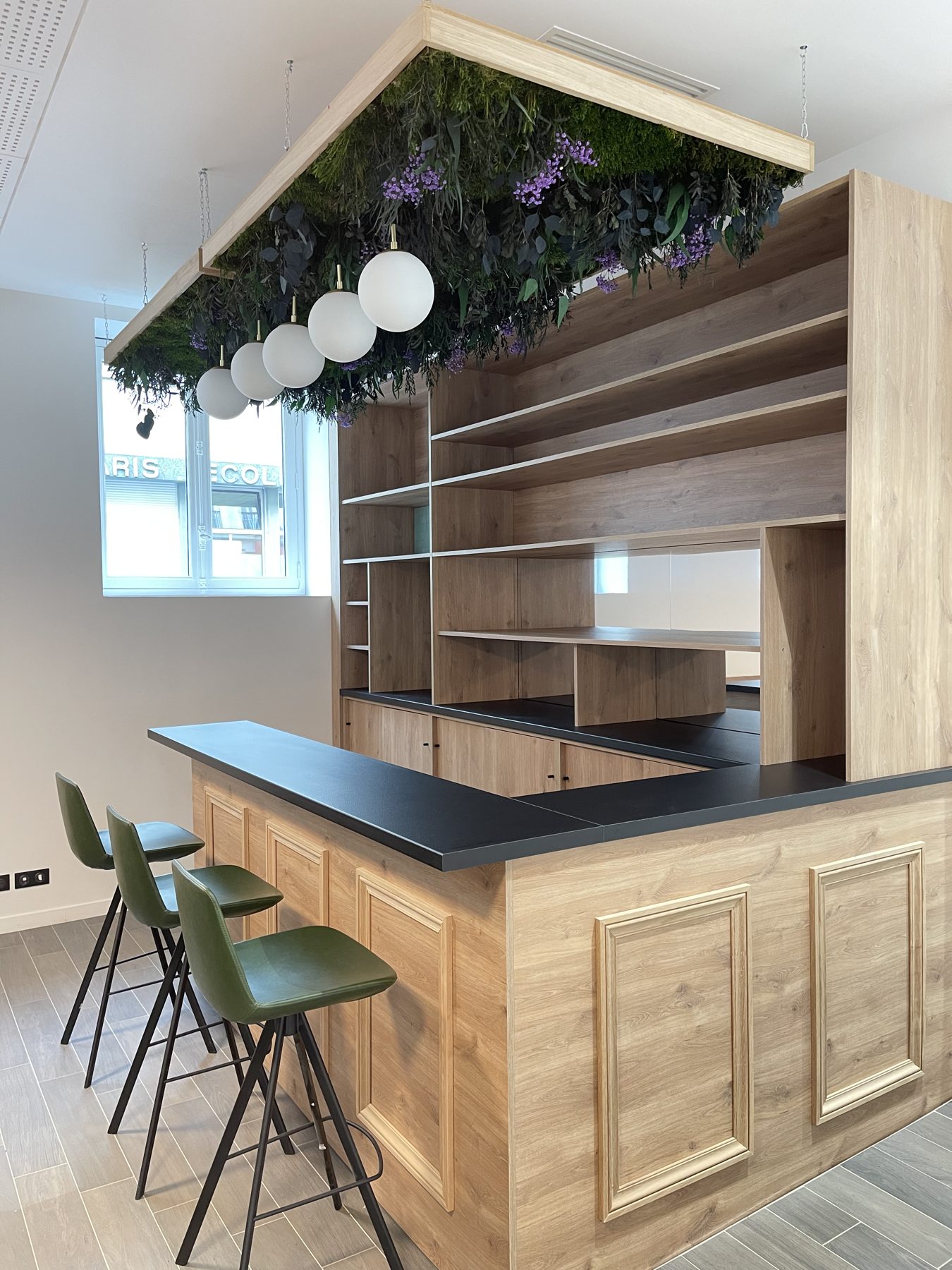 Plafond végétal stabilisé suspendu au-dessus d'un bar d'entreprise, mousses et feuillages stabilisés avec suspensions lumineuses — réalisation Garden Events (Colonies)